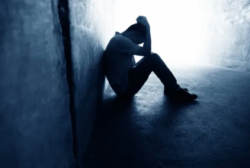 man sitting in a tunnel with head in his hands